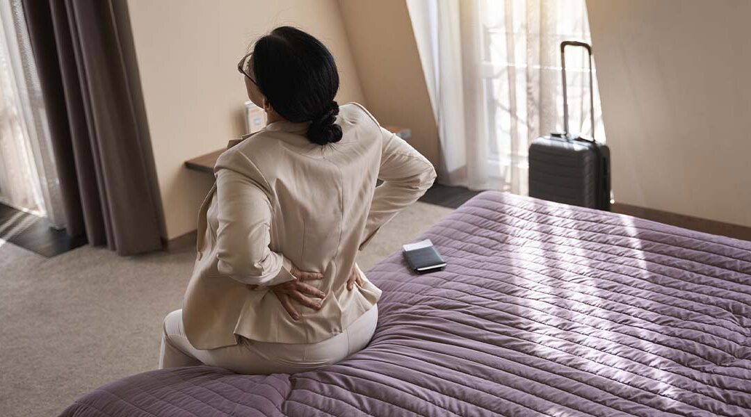 Women on bed experiencing back pain